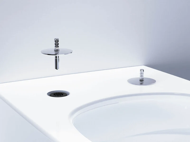 Gros plan sur un bidet blanc moderne avec une robinetterie chromée minimaliste et un bouton de commande devant un mur gris clair.