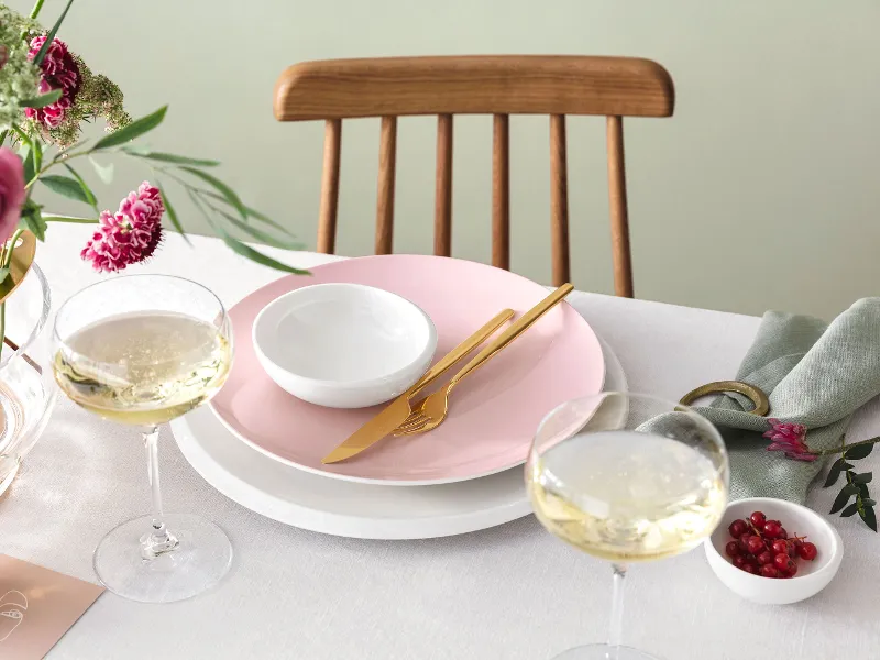 Elegant dining table decoration with Rose Garden and New Moon crockery, a floral centrepiece and gold MetroChic cutlery.