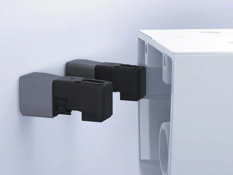 Deux supports muraux noirs fixent l'arrière d'un WC blanc au mur.