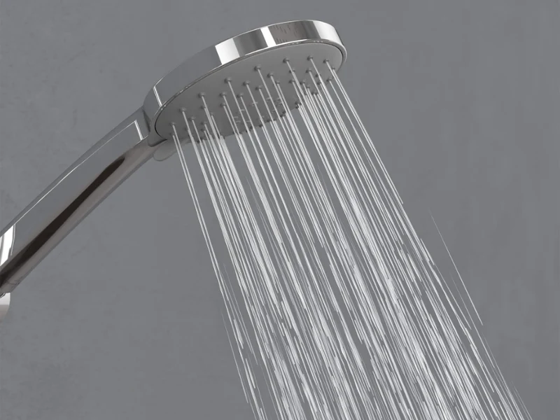 Universal Showers hand shower in Relax mode A chrome shower head spraying streams of water downward against a simple grey background.