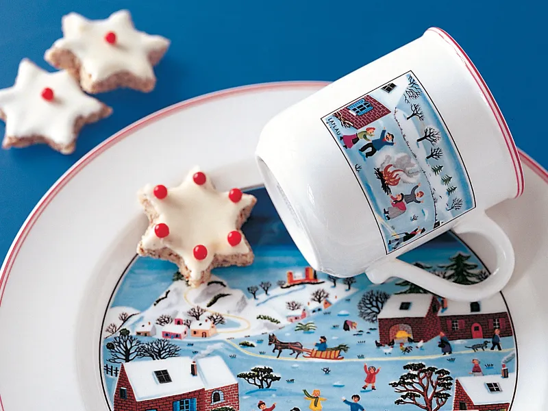 Design Naif Christmas mug placed on a plate with a star shaped cookie.