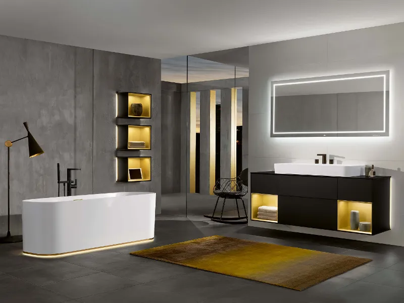 A white Finion bath in a modern grey bathroom with lighting.