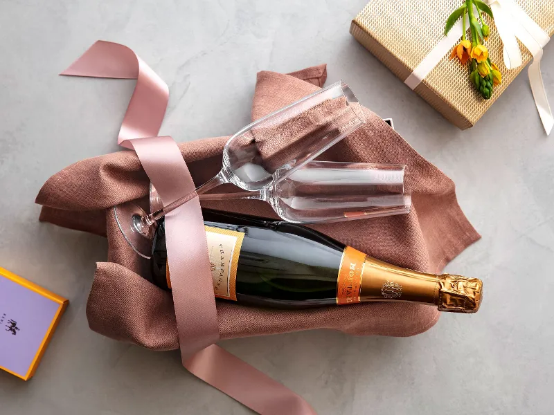 A bottle of champagne and Rose Garden champagne flutes in a gift box.