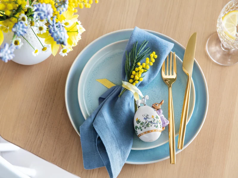 Elegantly laid table with blue Crafted crockery and the Annual Easter Edition 2022 egg An elegantly laid table with blue Crafted crockery and a decorative egg from the Annual Easter Edition 2022 together with a spring floral arrangement.