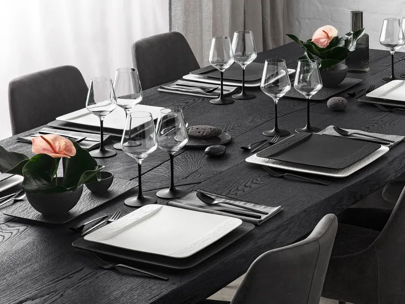 A black table setting with glasses, rectangular crockery and cutlery from the Villeroy & Boch Manufacture collection.