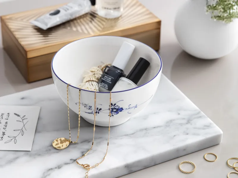 Elegant corner in the bathroom with skincare products, jewellery and fresh flowers with an Old Luxembourg porcelain bowl.