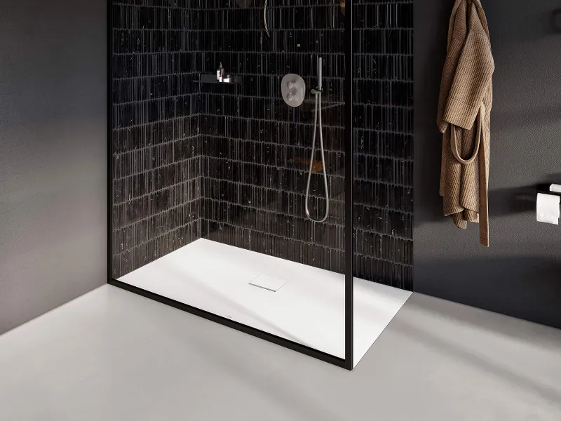 A black and white bathroom with a glass shower cubicle and a Squaro Infinity shower tray.