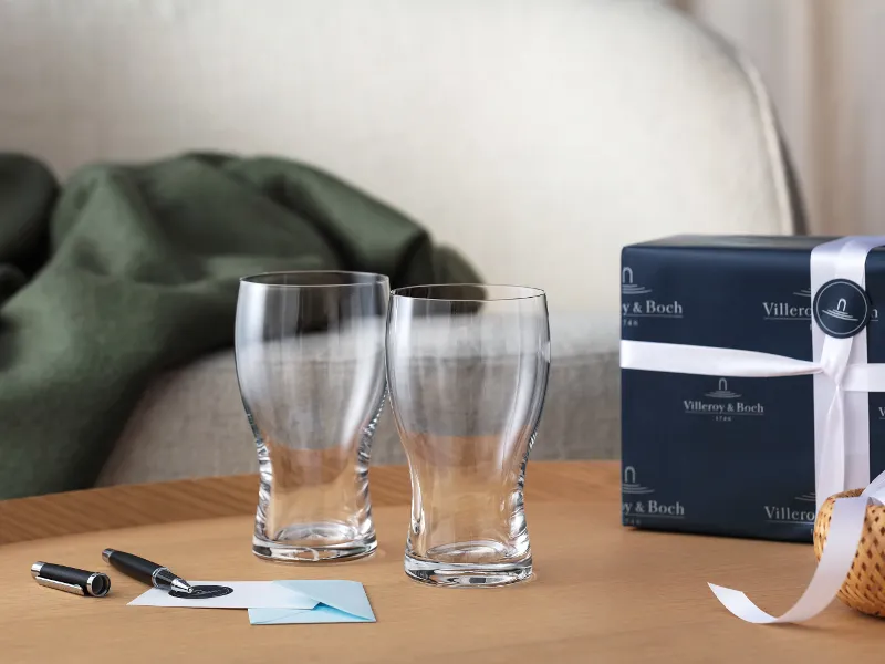 Two Villeroy & Boch Purismo beer glasses as a gift with a card and a fountain pen and a gift box in the background