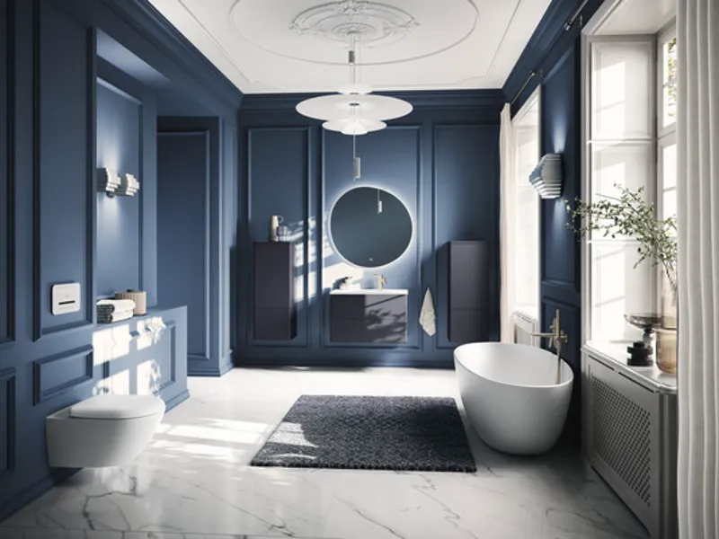 Elegante bagno Antao blu navy con vasca freestanding Bagno moderno con pareti blu navy, vasca freestanding bianca e specchio rotondo della collezione Antao, illuminato da ampie finestre con luce naturale.