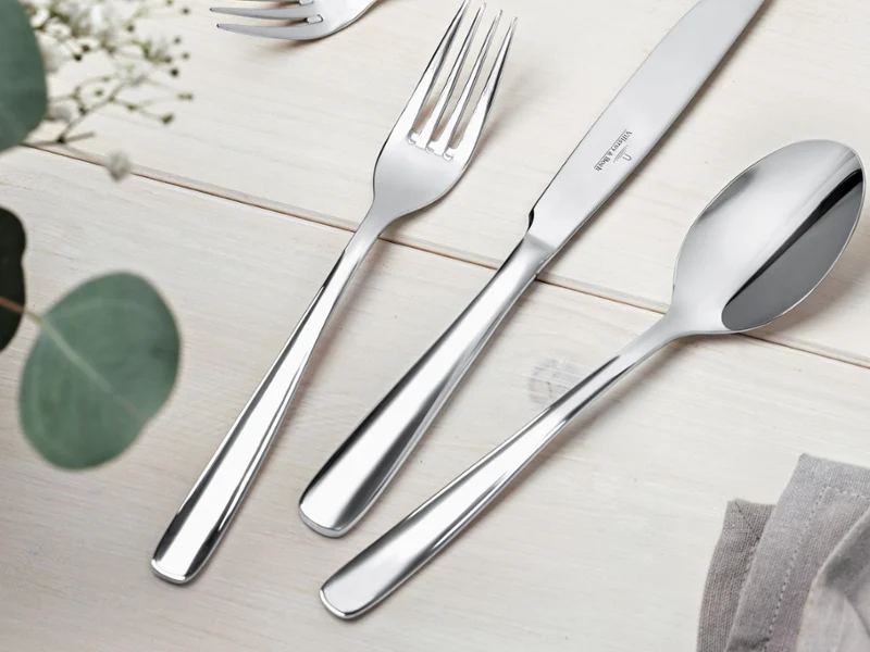 A silverware set featuring a spoon, fork, and knife arranged neatly on a table.
