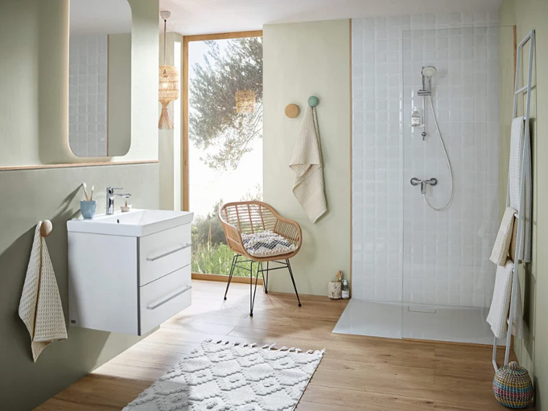 Bright bathroom with white vanity and shower area Bright bathroom with light wood floor, white vanity unit, and walk-in shower in soft green tones for a fresh and natural atmosphere.