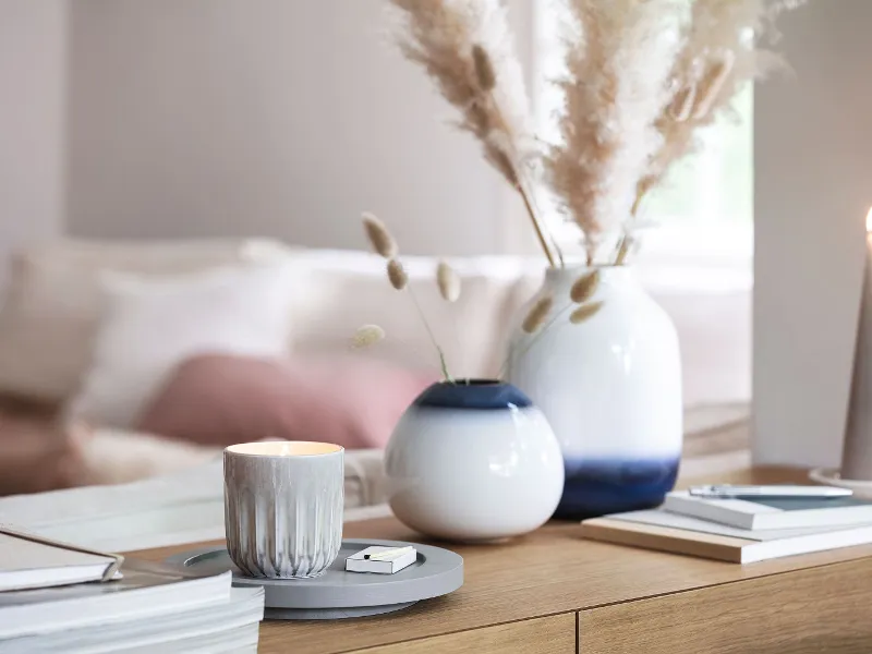 A living room with white and blue Lave vases, books and a Perlemor scented candle.