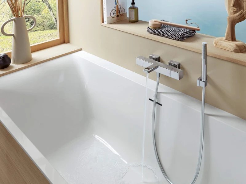 Moderno cuarto de baño con bañera blanca, detalles de madera y gran ventanal. La bañera tiene un grifo cromado y un mango de ducha. En el alféizar hay un jarrón, artículos de aseo y un objeto decorativo.