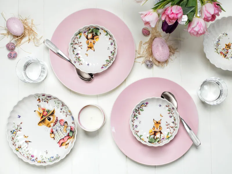 Easter-themed table decoration with decorated Spring Fantasy plates and Rose Garden plates as coasters together with flower arrangements.