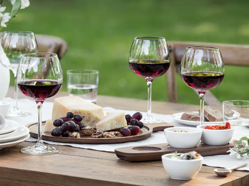 A table with Purismo red wine glasses, dip bowls and an antipasti platter from Artesano.