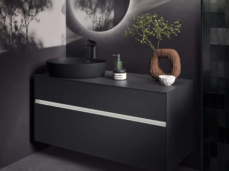 Eine elegante, moderne schwarze Memento 2.0 Wandtoilette unter einer weißen ViConnect Spülplatte und einem Fenster in der Nähe, das Tageslicht hereinlässt.