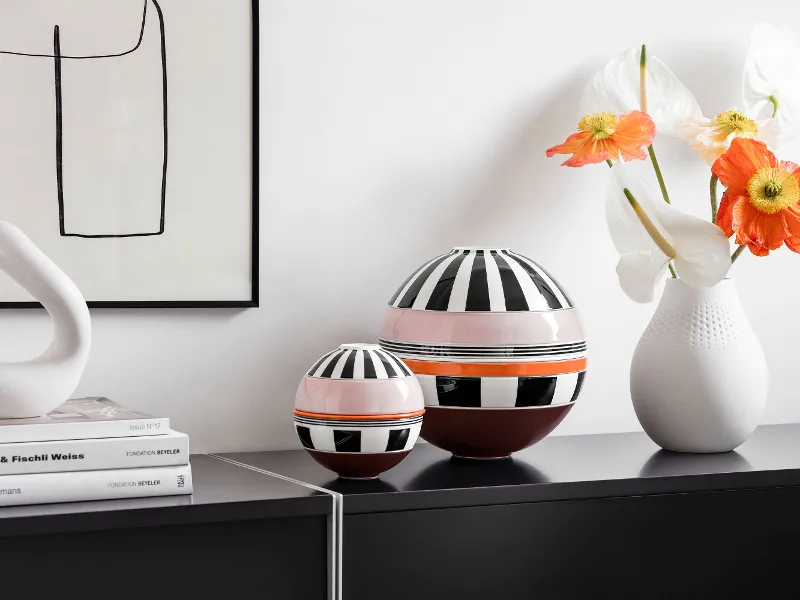 Auf einem schwarzen Regal steht die La Boule Memphis und die La petite Boule Memphis von Villeroy & Boch.