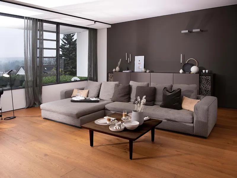 A living room with a coffee table set with a Villeroy & Boch beige La Boule and NewMoon glasses.