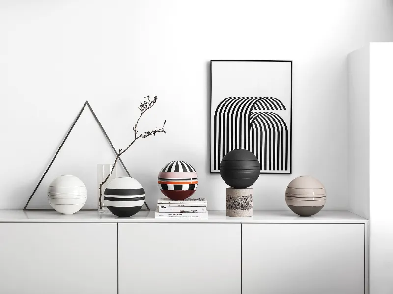 A white shelf with several La Boule crockery sets on top.