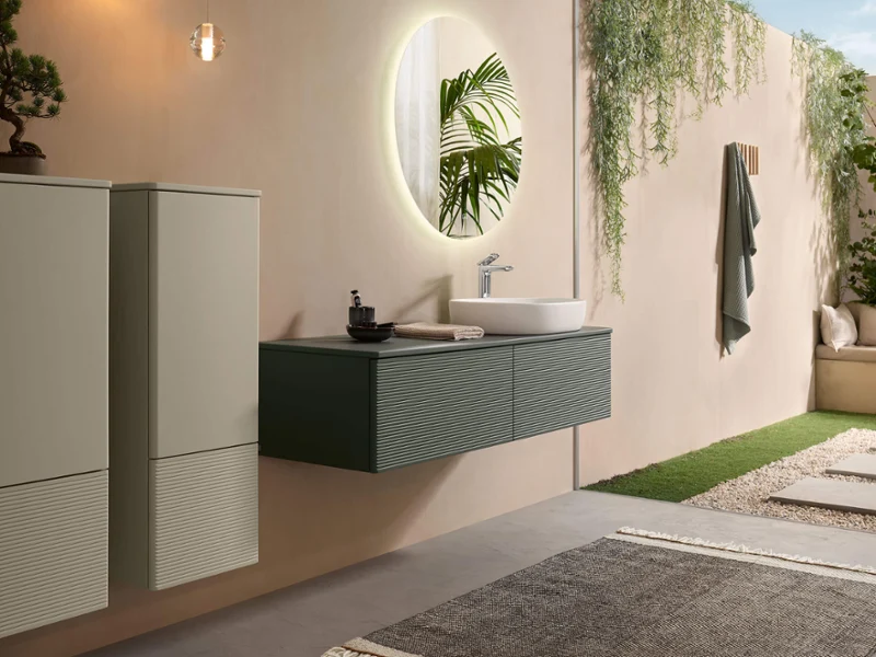 Une salle de bains avec des meubles de salle de bains modernes en vert et beige de la collection Antao de Villeroy & Boch.
