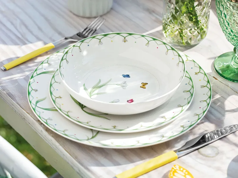 An outdoor table with a Colourful Spring setting and green Boston glasses under natural light.