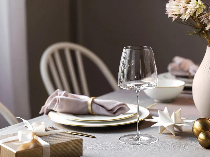 A table set for Christmas with an Anmut Gold wine glass and MetroChic crockery with gold decorations.