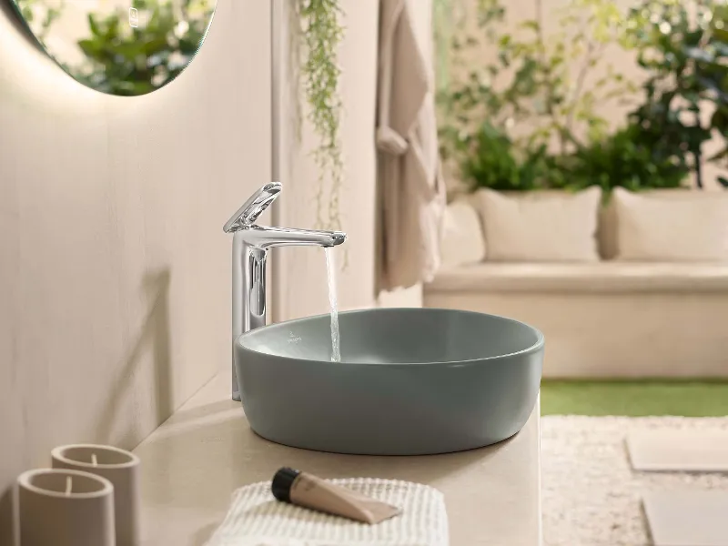 A green washbasin from the Villeroy & Boch Antao collection with a running tap.