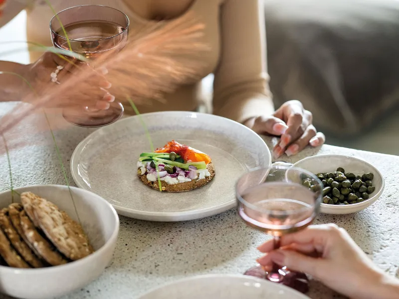 A group of people sitting at a table and eating crispbread from Perlemor plates.