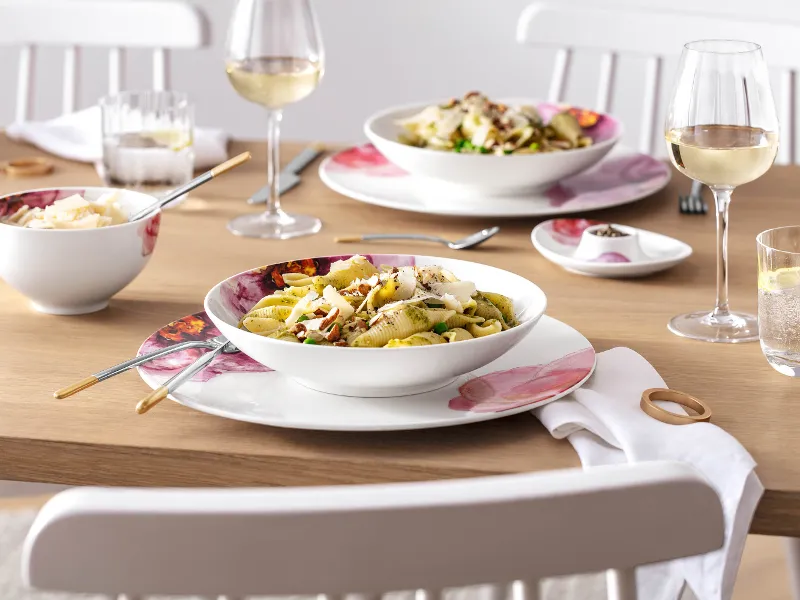 A Rose Garden pasta plate filled with conchiglie pasta and pesto, served with white wine in Rose Garden glasses and Ella cutlery from Villeroy & Boch.