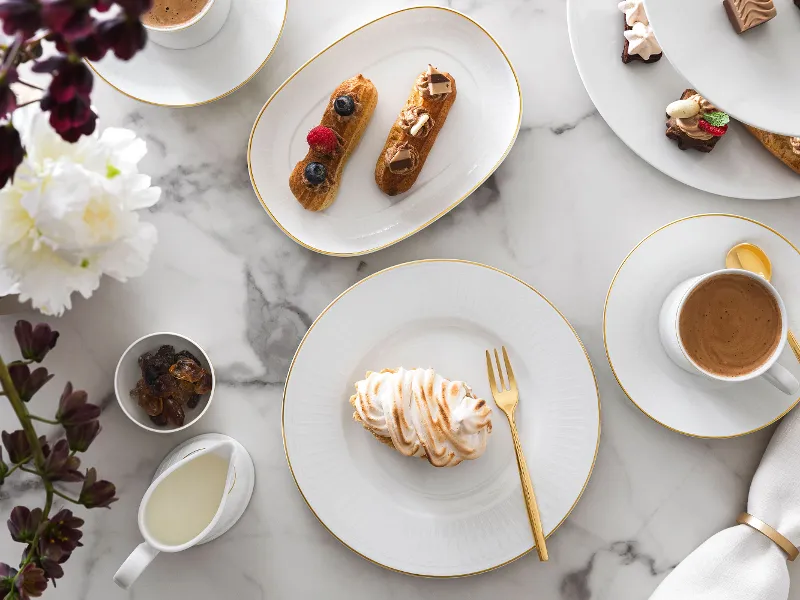 Elegant marble table with Château Septfontaines crockery and gold MetroChic cutlery.