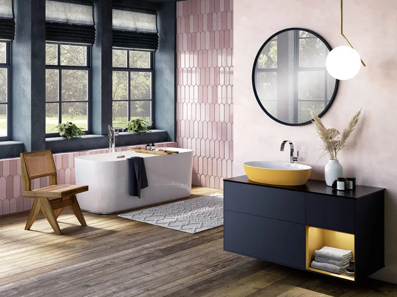 A yellow Artis washbasin on a dark vanity unit in a bathroom with a wooden floor and pink tiles.