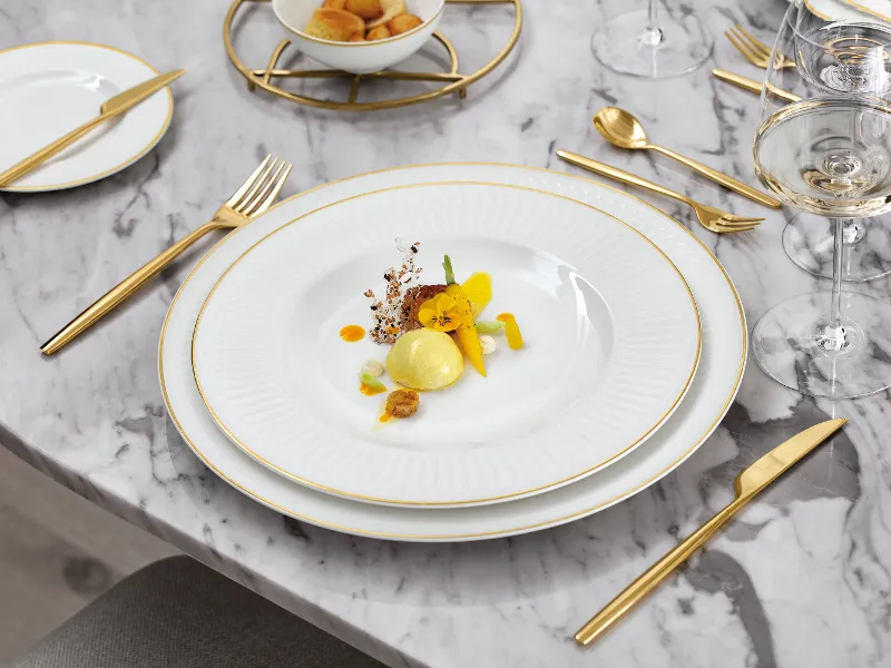 Elegantes Tischgedeck mit Villeroy & Boch Geschirr aus der Kollektion Château Septfontaines, goldenen Besteck und Gläsern.