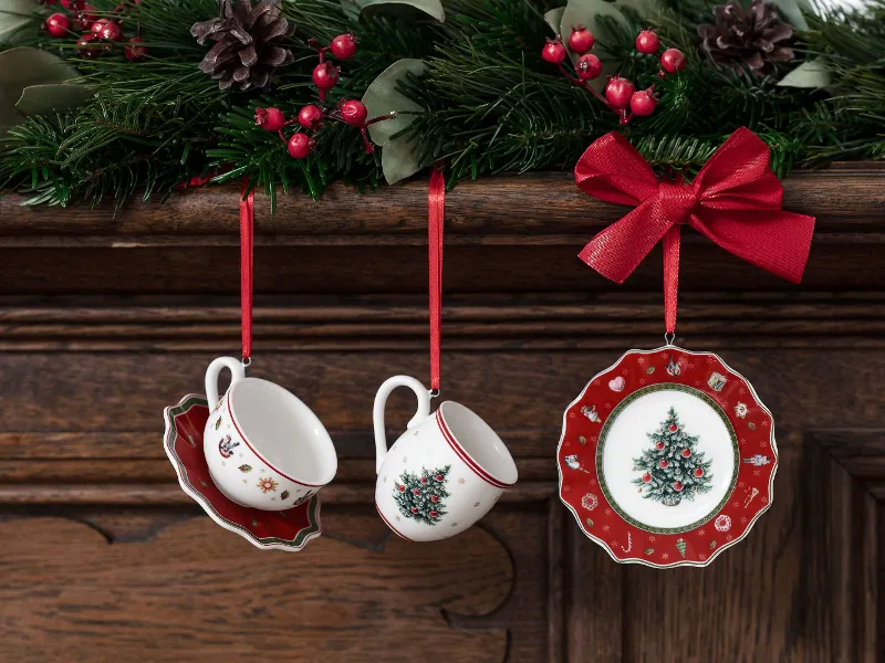 Toy’s Delight ornaments, hanging on red ribbons from a wooden mantelpiece decorated with mistletoe and berries.