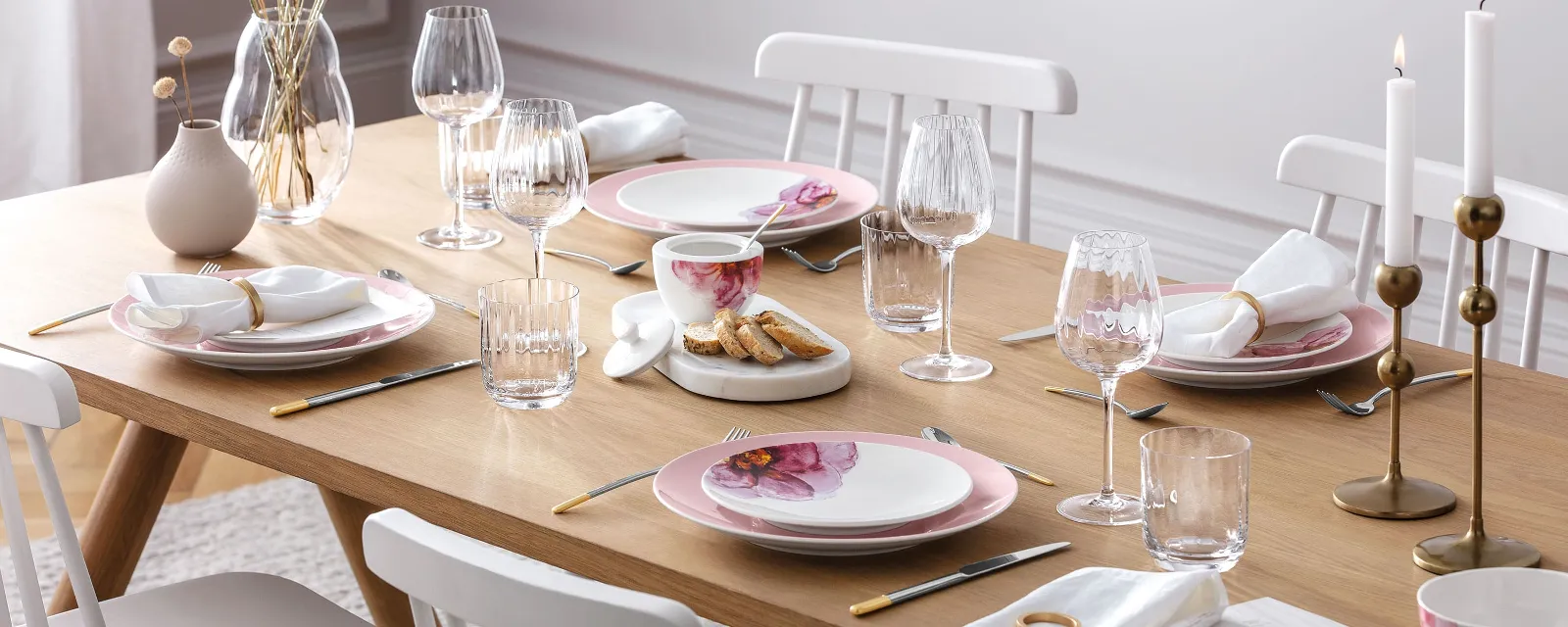 An elegant dining table with modern Rose Garden crockery, decorative candles and a Rose Garden vase with pampas grass.