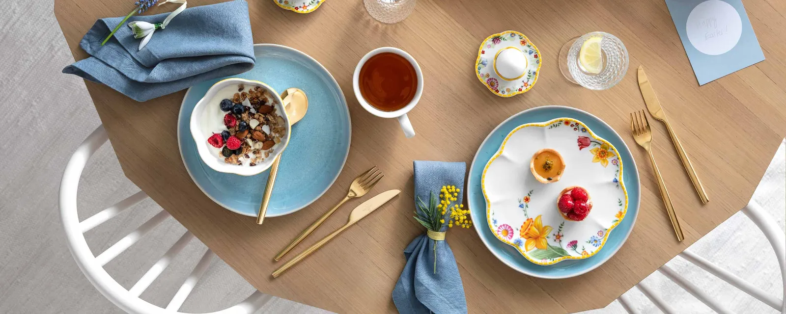 A springtime table setting with Spring Awakening and Crafted dinnerware, a Bundt cake, a serving bowl of oatmeal with berries, a cup of tea and decorative eggs.