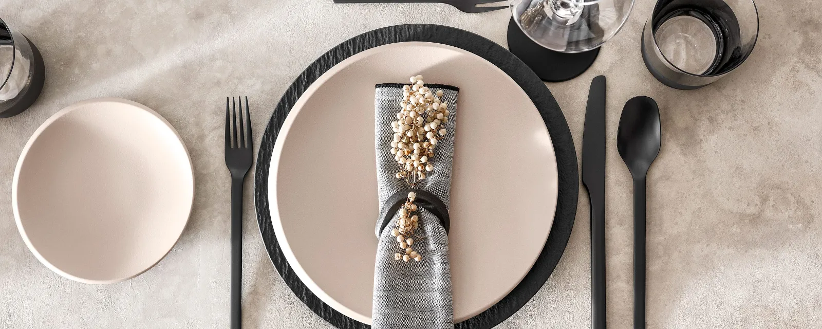 Modern table decoration with NewMoon crockery in beige and black Manufacture cutlery.