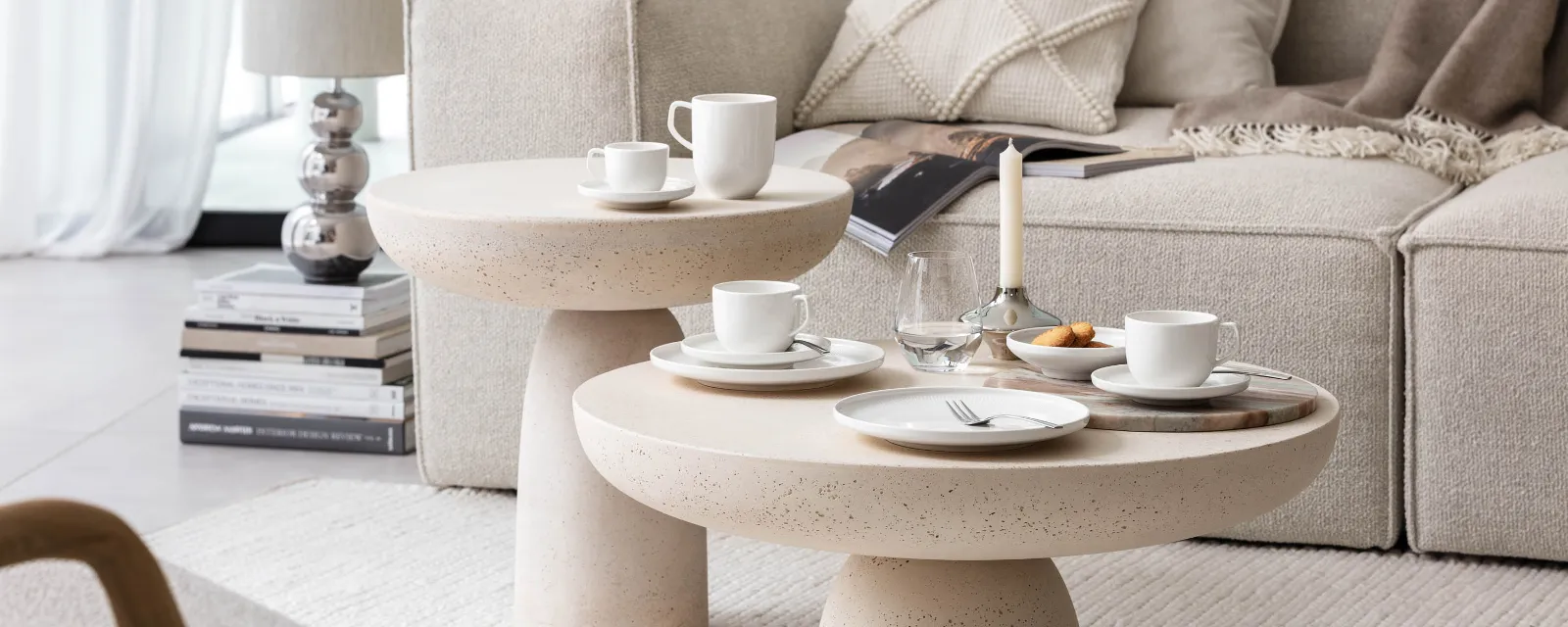 En hyggelig og moderne stue med en beige sofa, runde salongbord og et moderne kaffesett med kopper og tallerkener fra Afina-kolleksjonen fra Villeroy & Boch.