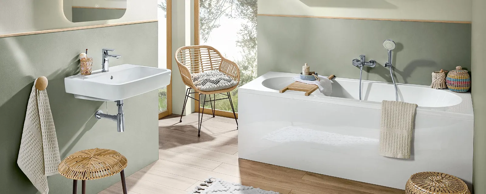 A bathroom with green walls, wooden furniture and a white O.novo bath and washbasin.