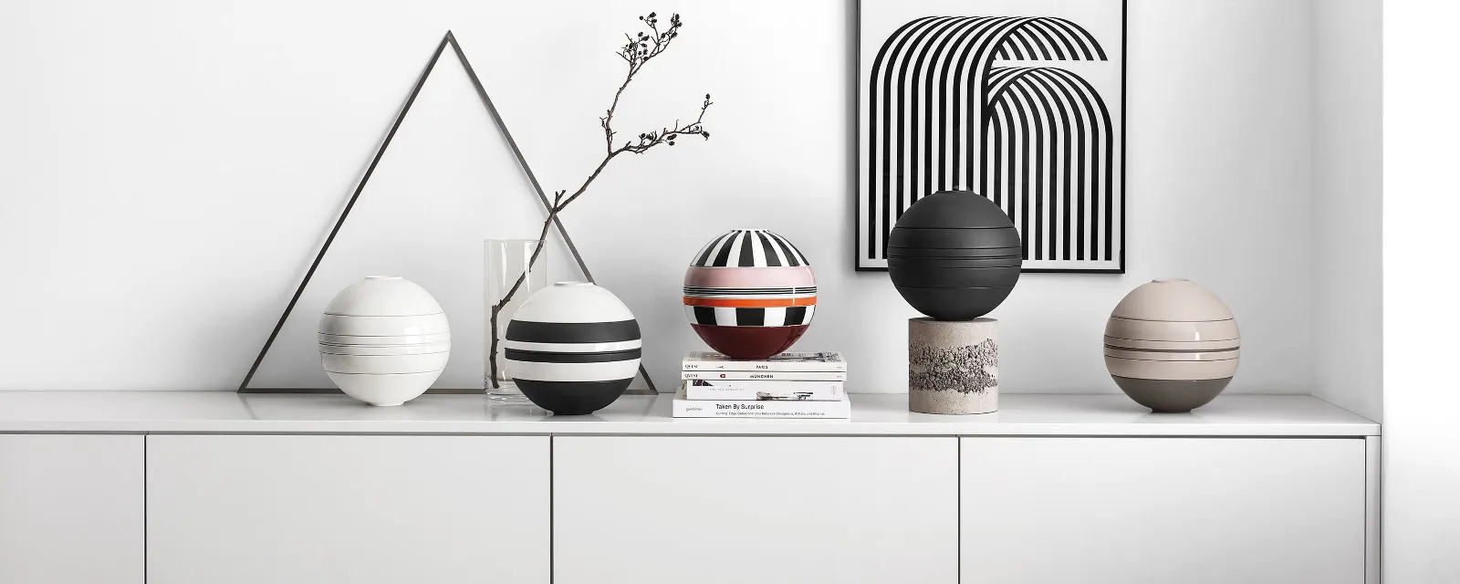 A white shelf with several La Boule crockery sets on top.