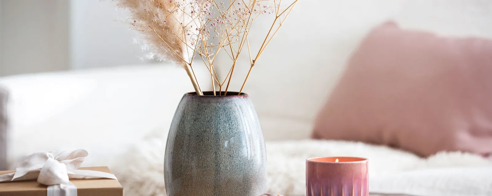 Wooden tray holding a Lave vase and a Perlemor candle with dried flowers, next to a wrapped gift.