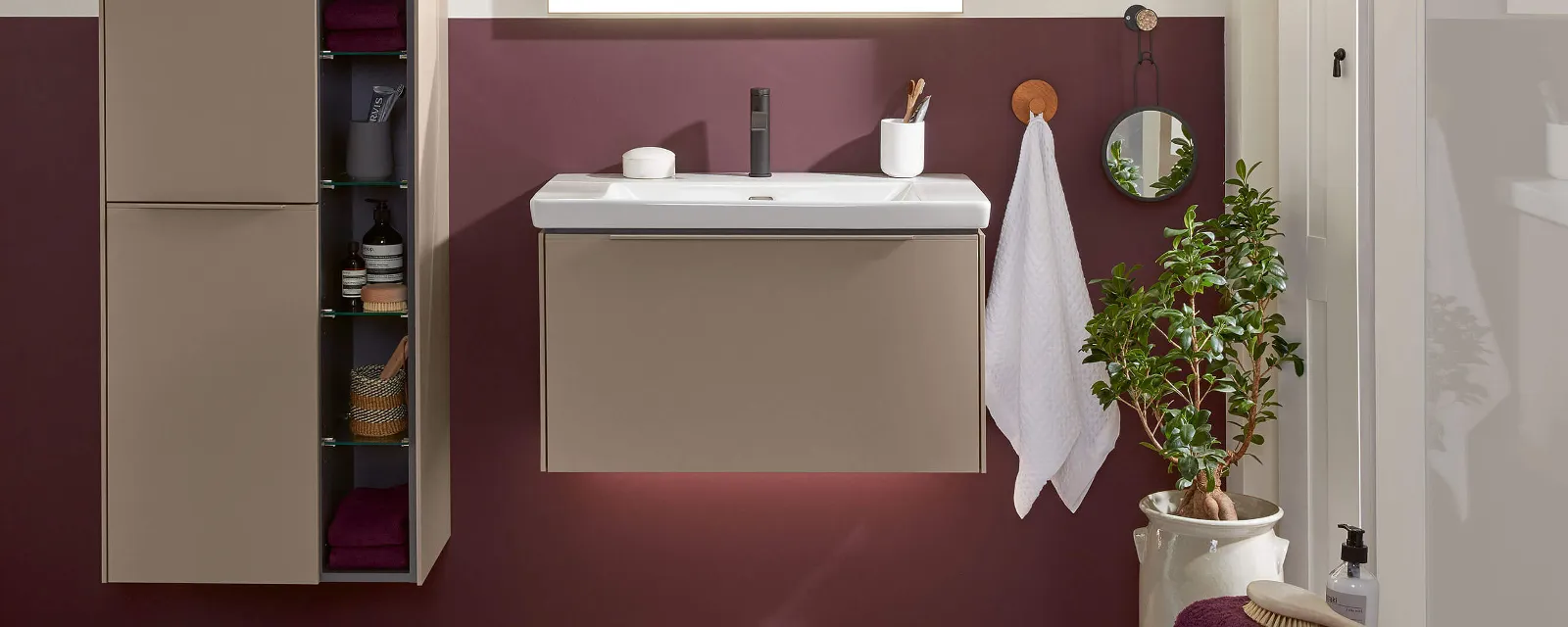 A bathroom with a Subway 3.0 washbasin, mirror and cabinet and a red wall.