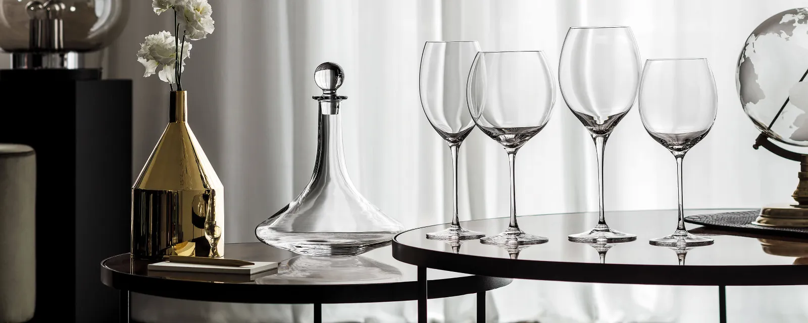 A group of Allegorie wine glasses and an elegant Vinobile wine decanter with flowers on a table.