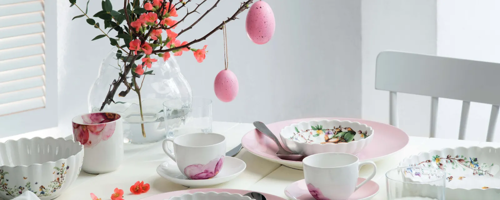 Pink plates from the Rose Garden collection on a table set with Easter decorations.