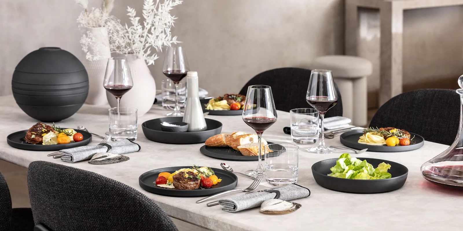 A dining table with a black La Boule being used for food as well as a fully assembled La Boule for decoration.