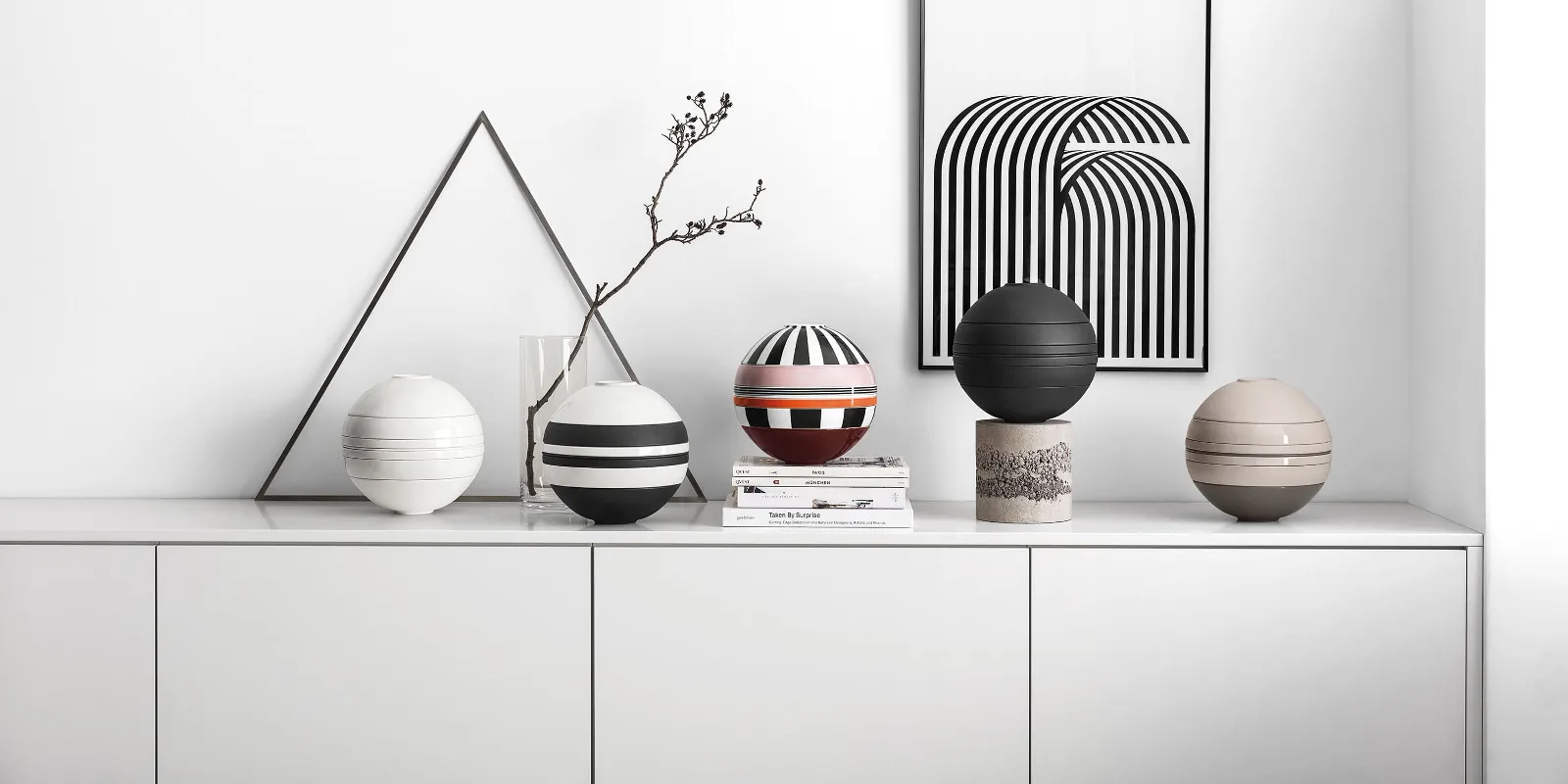 A white shelf with several La Boule crockery sets on top.