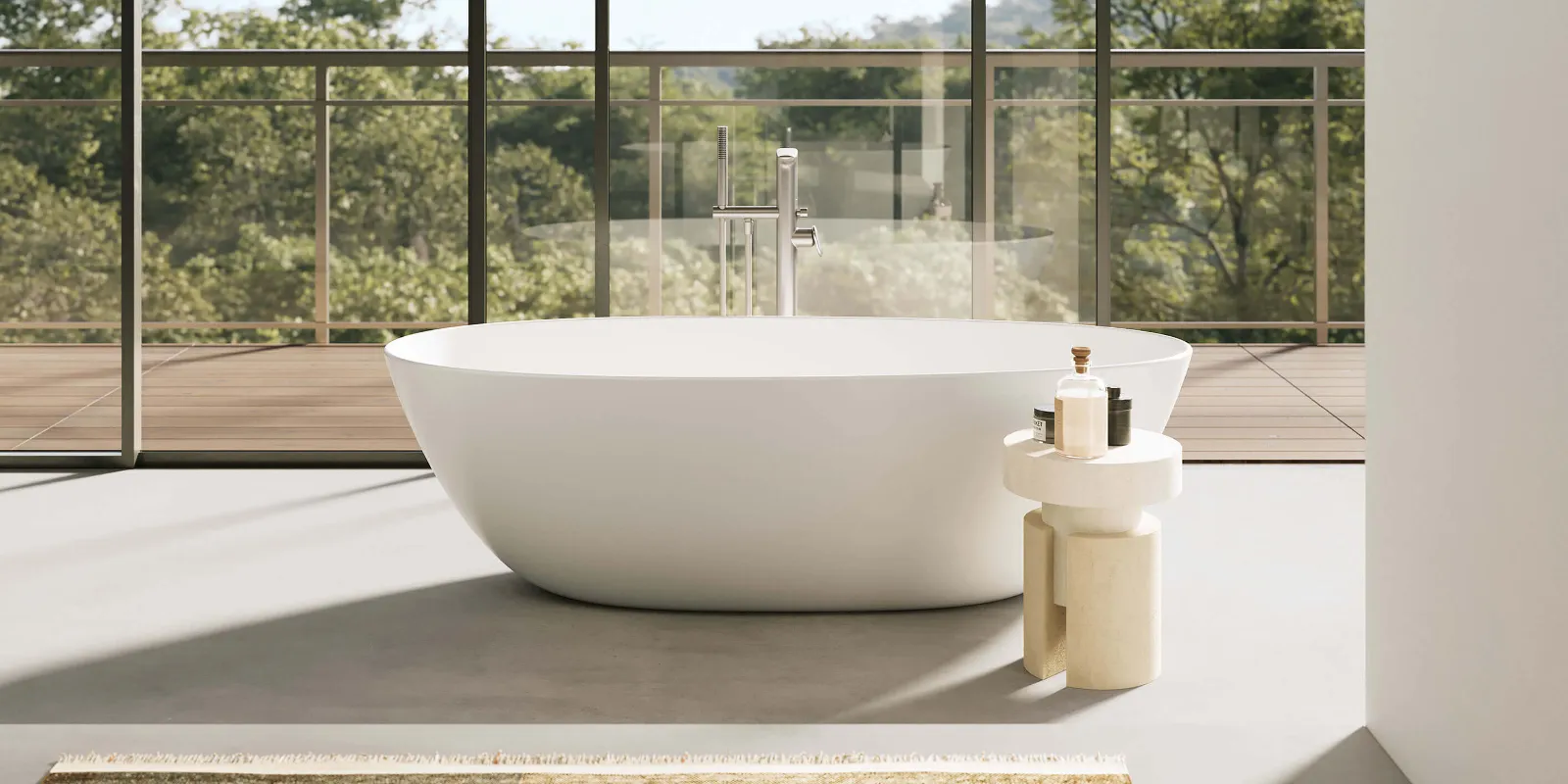 A white Antao bath in a room with a glass wall and trees.