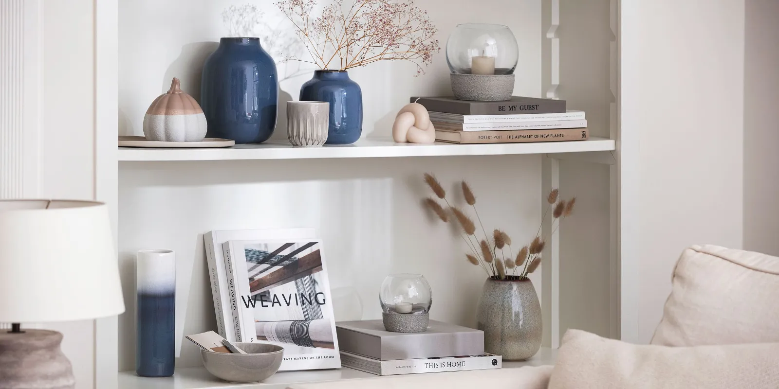 A living room with bookshelves and blue Lave vases from like. by Villeroy & Boch.