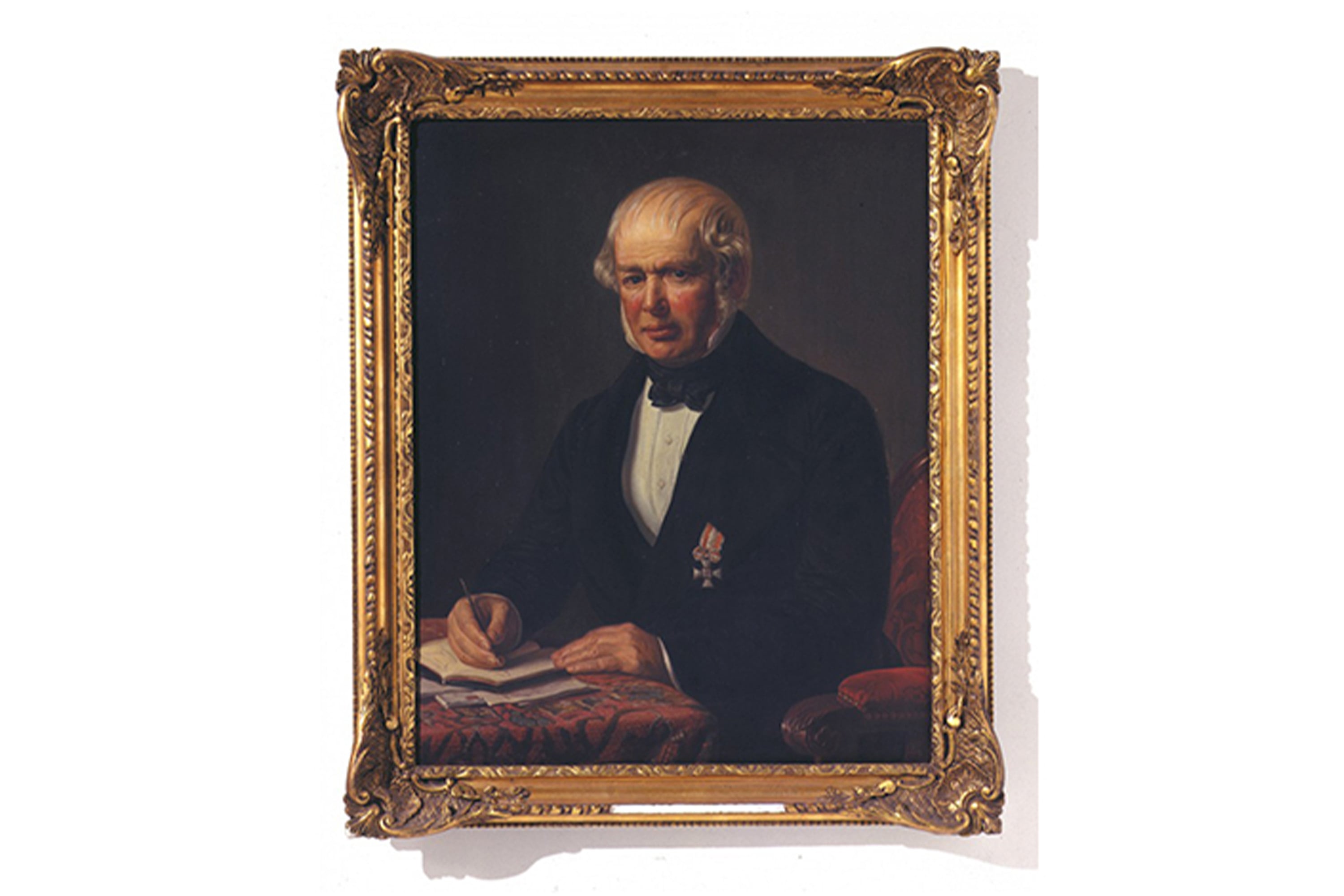vb-history-1836 A formal portrait of Eugen von Boch, seated and writing, displayed in an ornate gold frame.