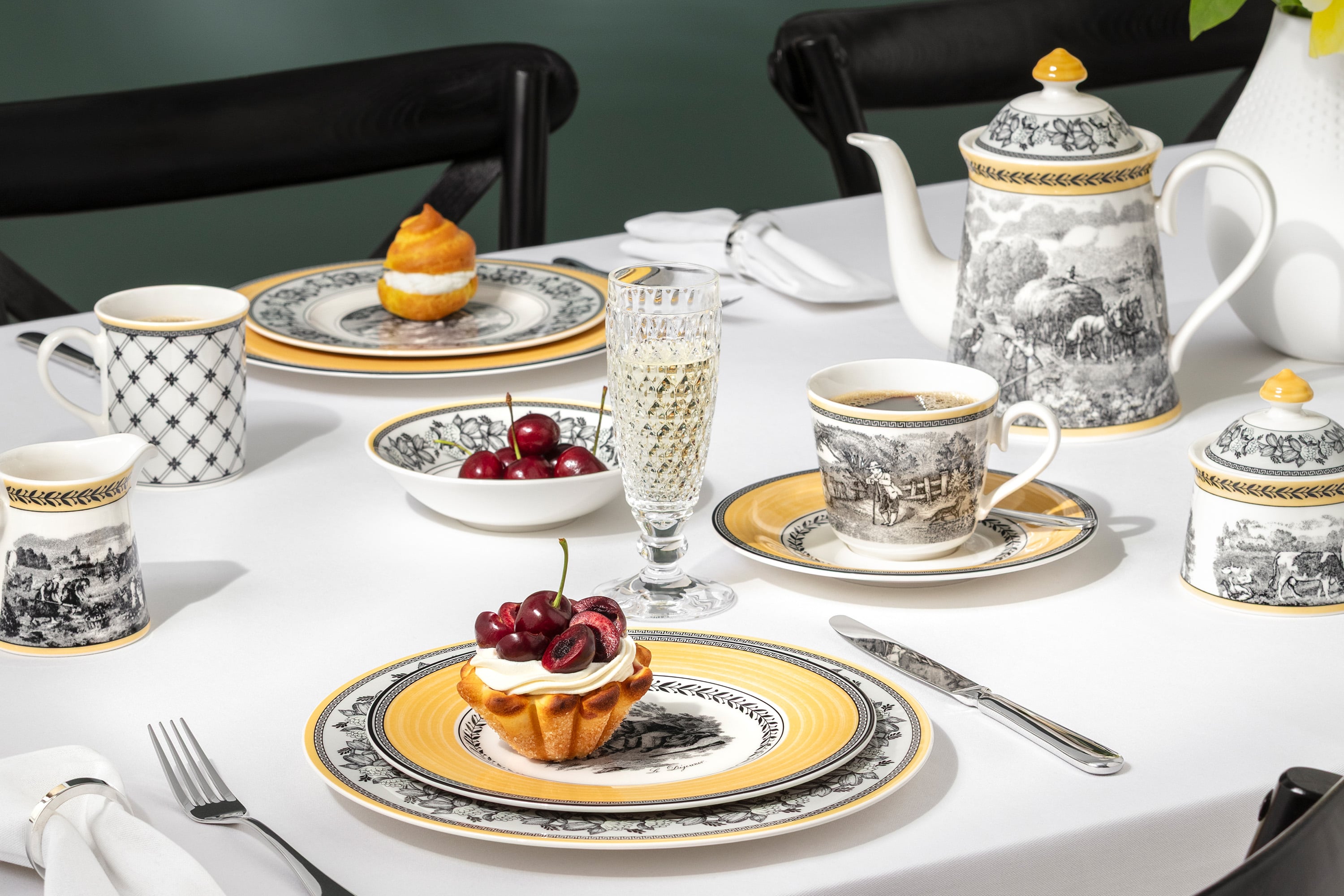 Élégante table à manger présentant la collection Audun, accompagnée de verres Boston et d'un assortiment de desserts.