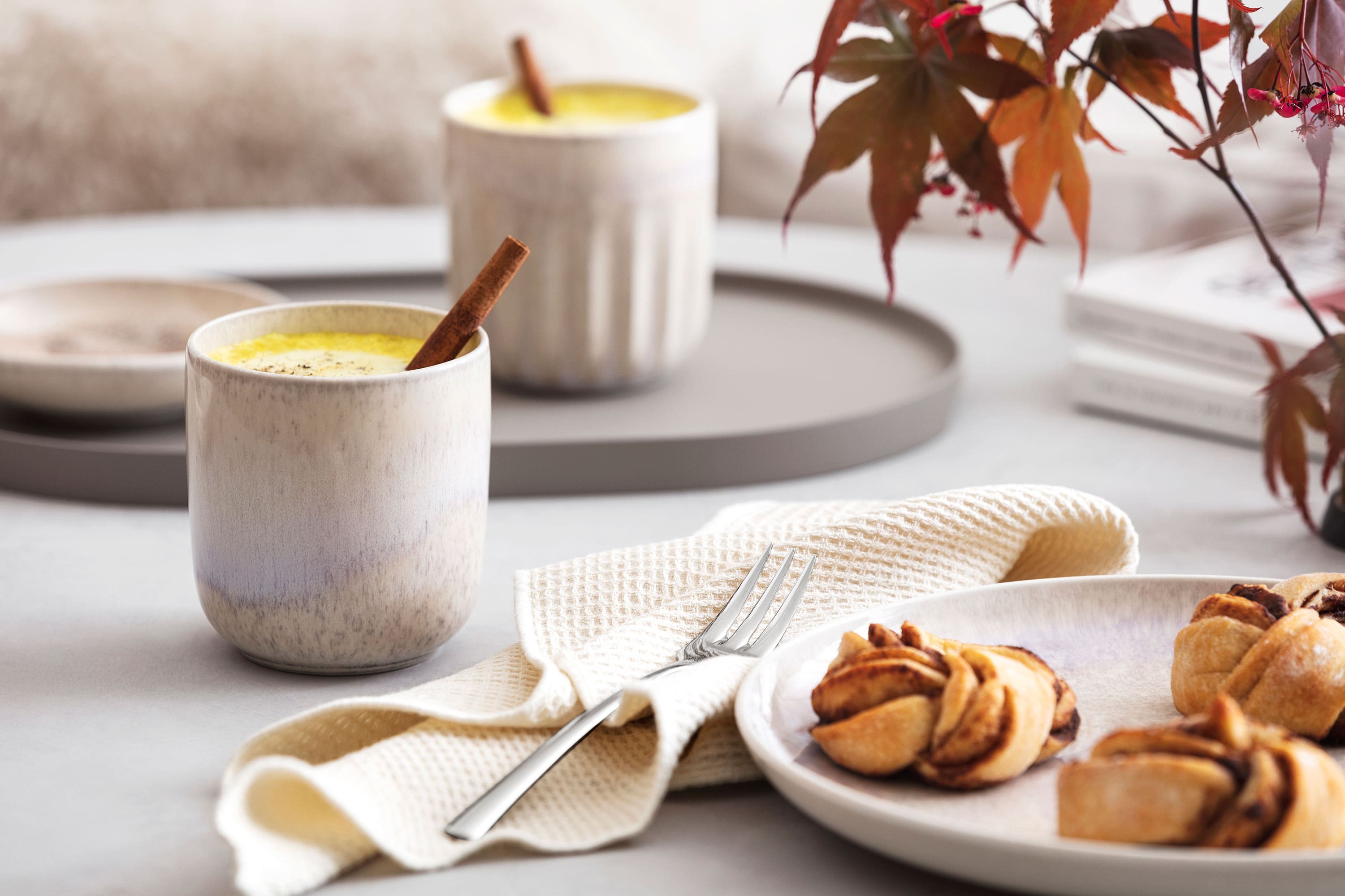 A plate with biscuits and a cup of coffee in a like. by Villeroy & Boch Perlemor mug on a table.